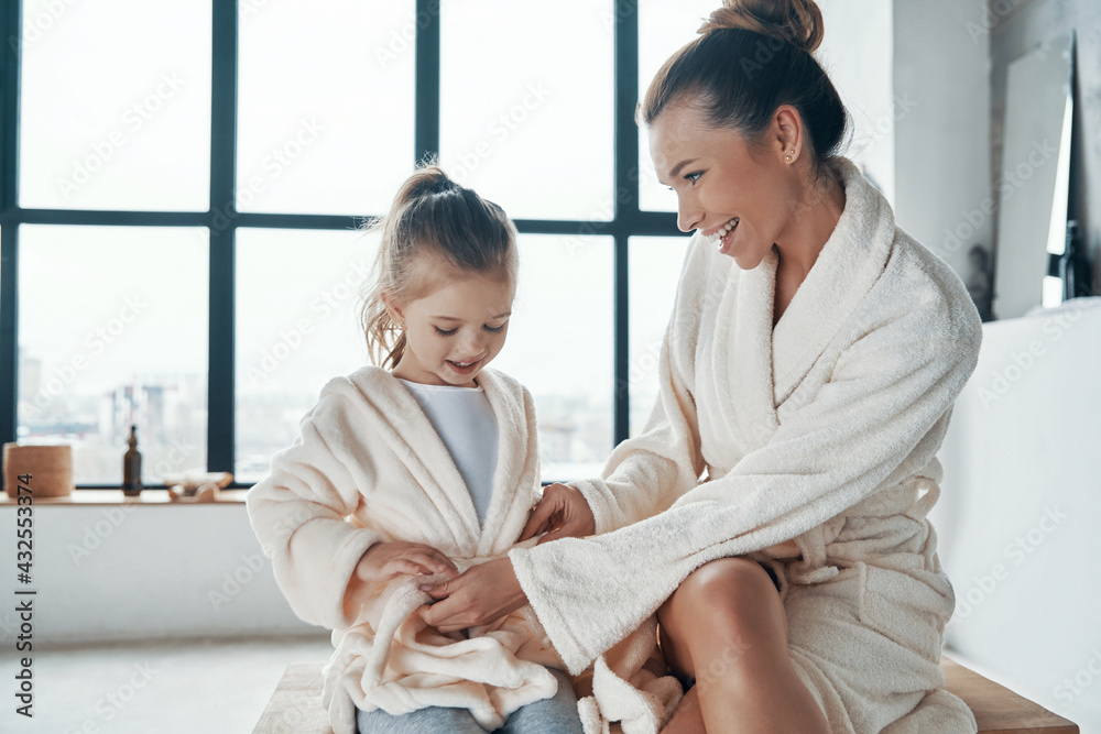 Mother with daughter in bathrobes smiling Mother with daughter in bathrobes smiling