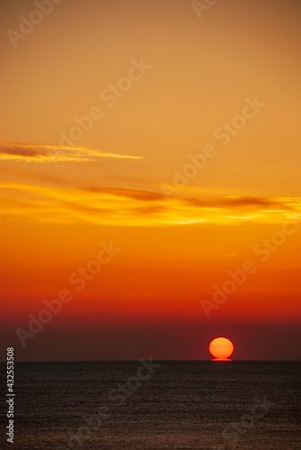 Fototapeta Naklejka Na Ścianę i Meble -  Seascape at sunset. The red disk of the sun is beyond the horizon.