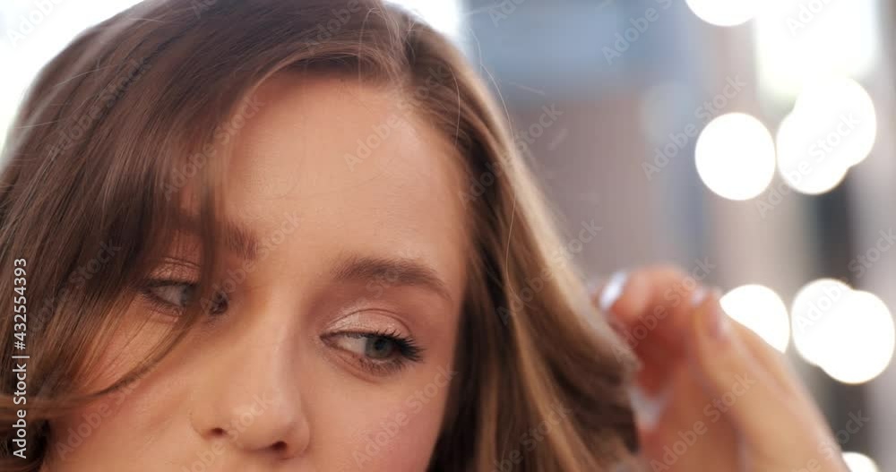 Young woman doing hairstyle in beauty salon. Close-up.