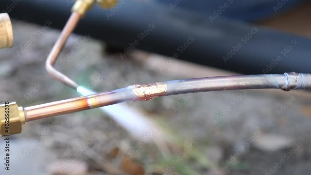 Maintenance worker using an acetylene torch to weld a pipe Maintenance worker using an acetylene torch to weld a pipe