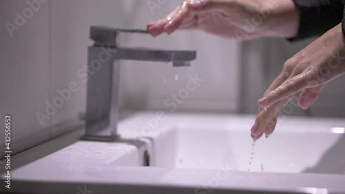 Person shutting water faucet, finishing washing hands, saving conserving water