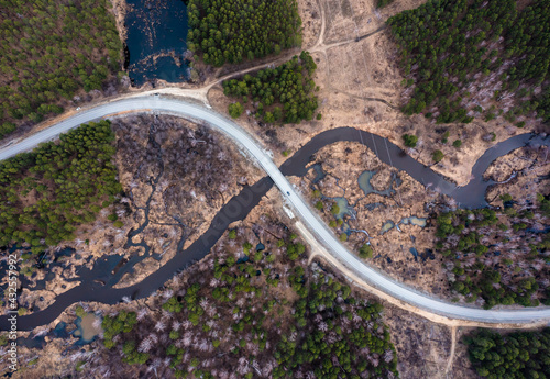 intersection of a road and a river in the form of an infinity sign, nature view from a drone.