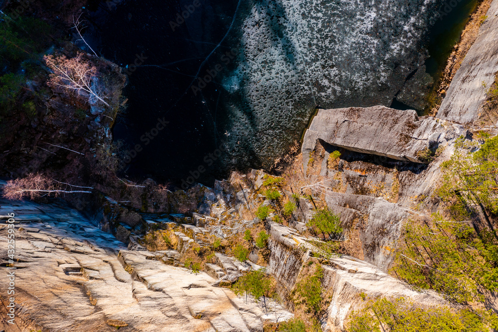 edge of the forest on the rock of a stone quarry with water, a view from a drone edge of the forest on the rock of a stone quarry with water, a view from a drone