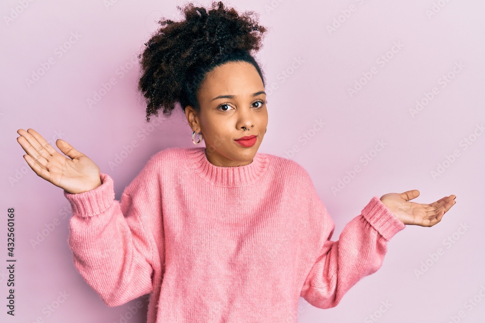Young african american girl wearing casual clothes clueless and confused with open arms, no idea and doubtful face. Young african american girl wearing casual clothes clueless and confused with open arms, no idea and doubtful face.