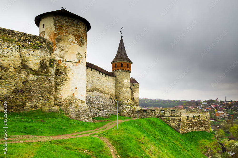 The part of Old Kamianets-Podilskyi Castle under a cloudy grey sky. The fortress located among the picturesque nature in the historic city of Kamianets-Podilskyi, Ukraine
