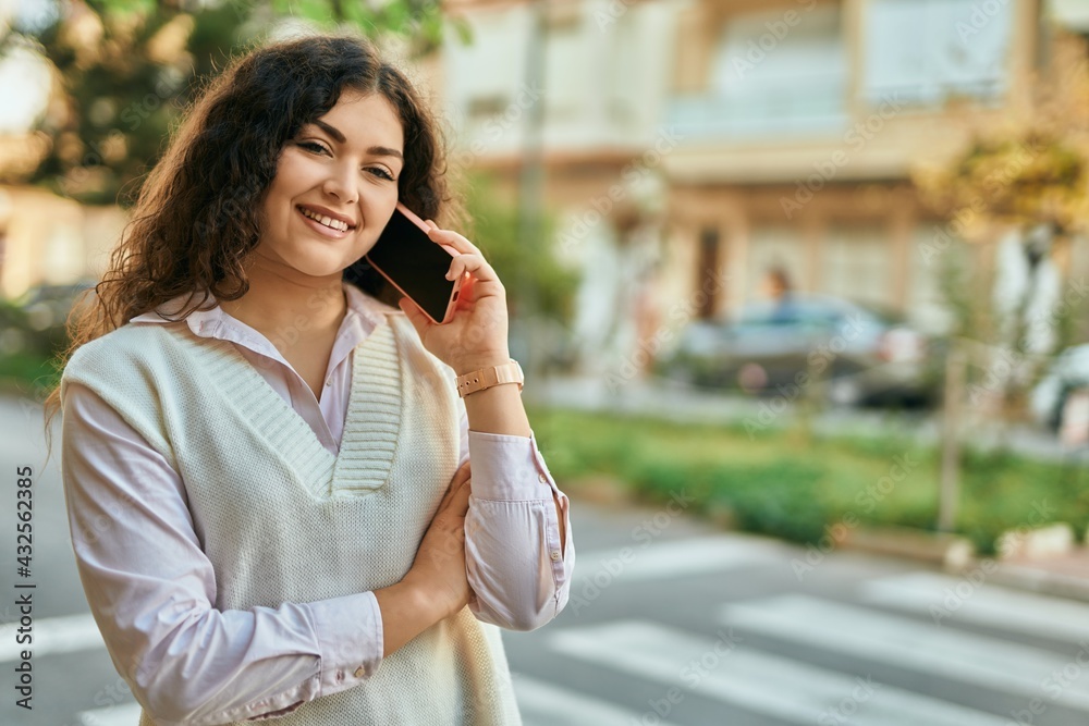Young hispanic woman smiling happy talking on the smartphone at the city. Young hispanic woman smiling happy talking on the smartphone at the city.