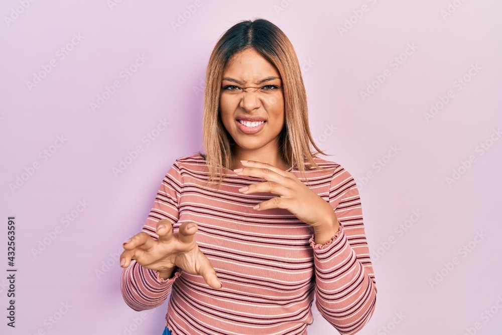 Obraz premium Beautiful hispanic woman wearing casual striped sweater disgusted expression, displeased and fearful doing disgust face because aversion reaction. with hands raised