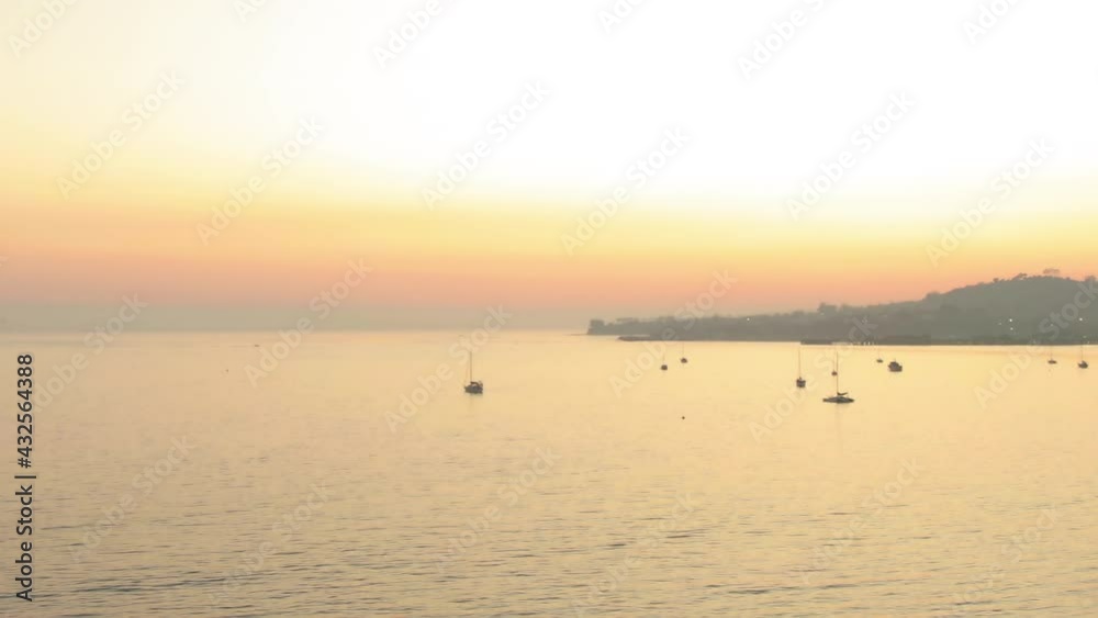 Aerial Panning Shot Of Silhouette Boats On Sea Against Orange Sky, Drone Flying Backward Over Butterfly Beach At Sunset - Santa Barbara, California Aerial Panning Shot Of Silhouette Boats On Sea Against Orange Sky, Drone Flying Backward Over Butterfly Beach At Sunset - Santa Barbara, California