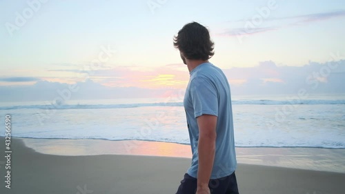 Bodysurfer. Young bodysurfer walks with fins and handplane on the beach at sunrise photo