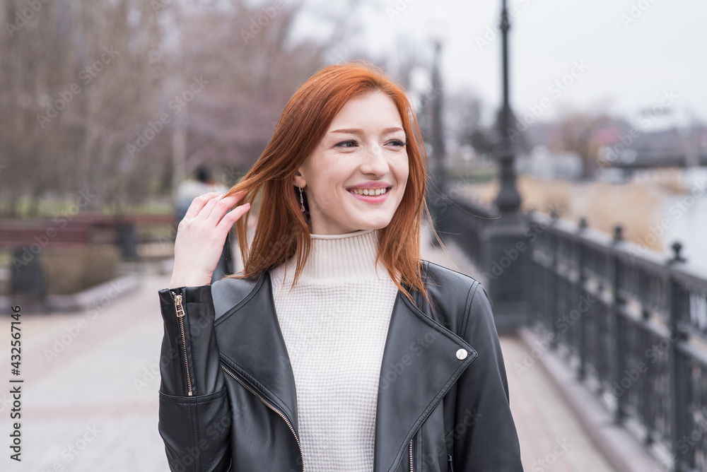 Portrait of a beautiful and positive redhead woman with clothes in grunge style. Posing while walking Portrait of a beautiful and positive redhead woman with clothes in grunge style. Posing while walking