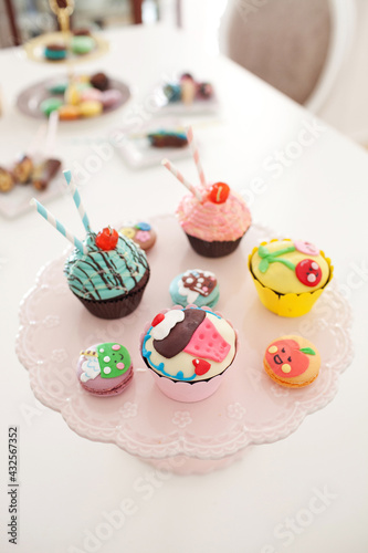 Close up image of assorted colorful cupcakes and macaroons