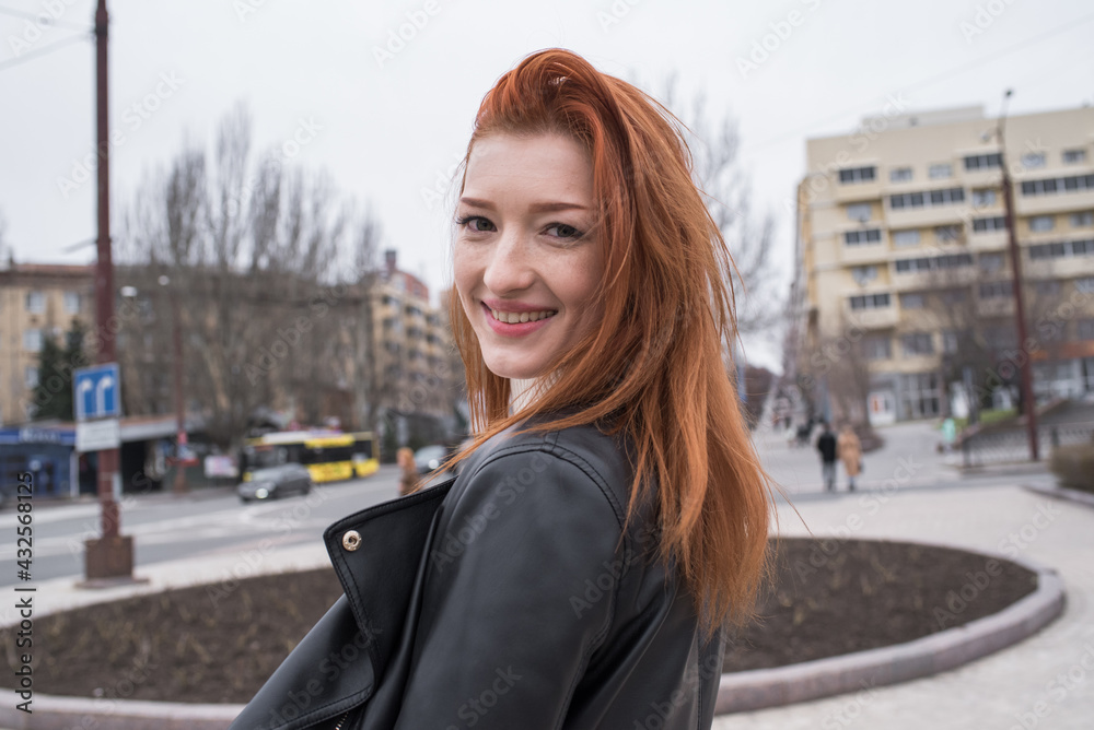 Portrait of a beautiful and positive redhead woman with clothes in grunge style. Posing while walking Portrait of a beautiful and positive redhead woman with clothes in grunge style. Posing while walking