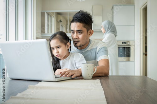father or husband working from home while child is sitting on his lap