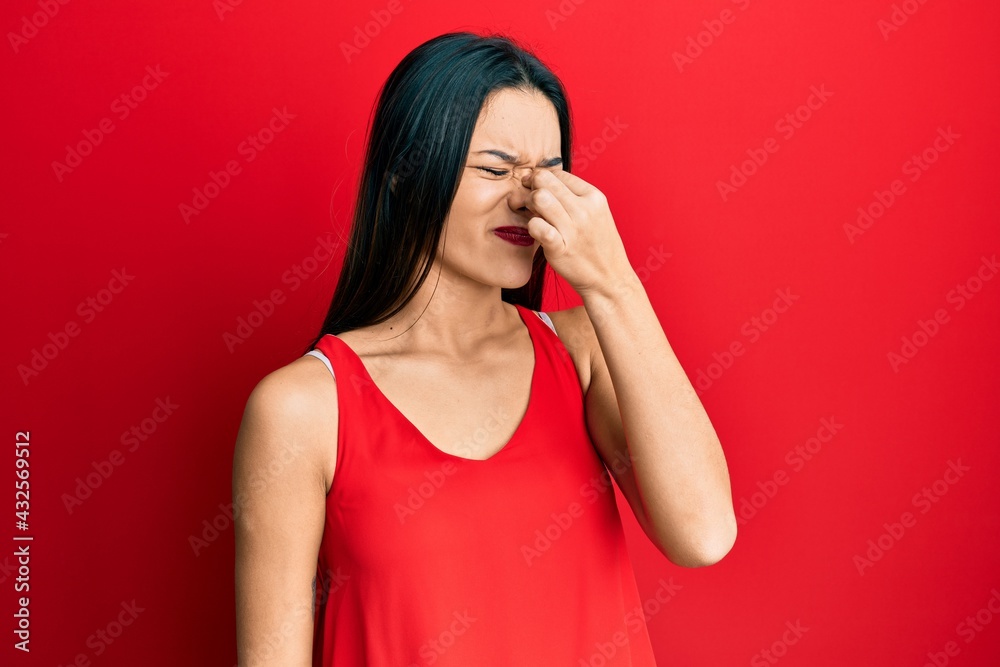 Young hispanic girl wearing casual style with sleeveless shirt tired rubbing nose and eyes feeling fatigue and headache. stress and frustration concept. Young hispanic girl wearing casual style with sleeveless shirt tired rubbing nose and eyes feeling fatigue and headache. stress and frustration concept.