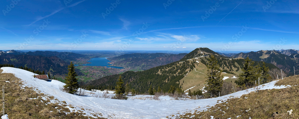 Wandern in den Alpen, Oberbayern: Panorama vom Gipfel des Setzberg mit Blick auf den schönen blauen Tegernsee und den Wallberg mit Schnee