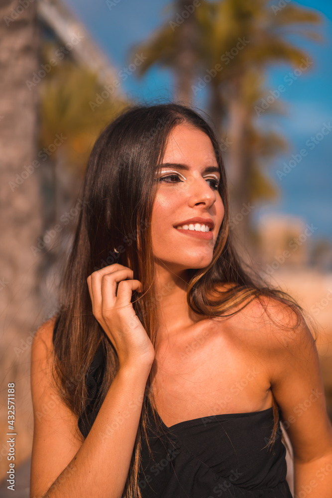 Summer lifestyle, portrait of a brunette Caucasian in short pants and black t-shirt on the Mediterranean coast sitting by the sea