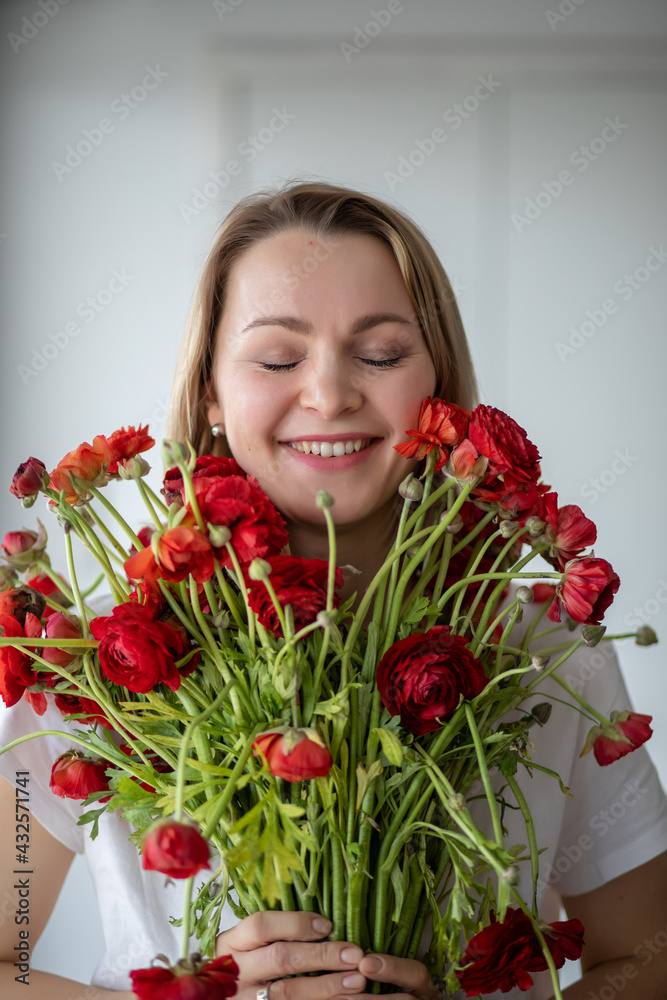 Girl in white T-shirt holds a bouquet of red flowers Girl in white T-shirt holds a bouquet of red flowers