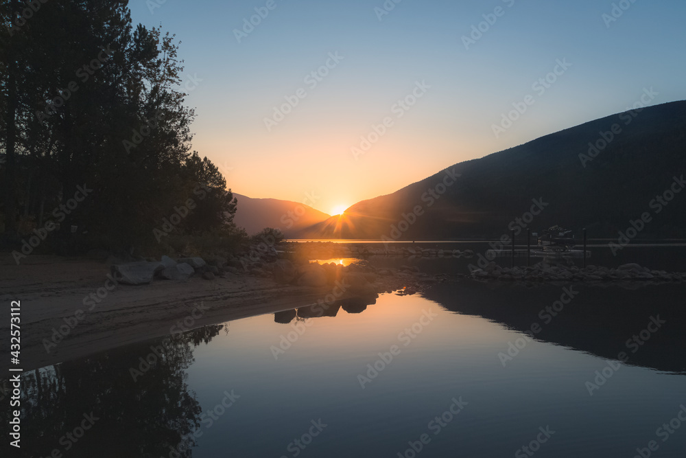 A beautiful, peaceful, serene, calm, idyllic summer sunset or sunrise on Kootenay Lake in Nelson, British Columbia, Canada
