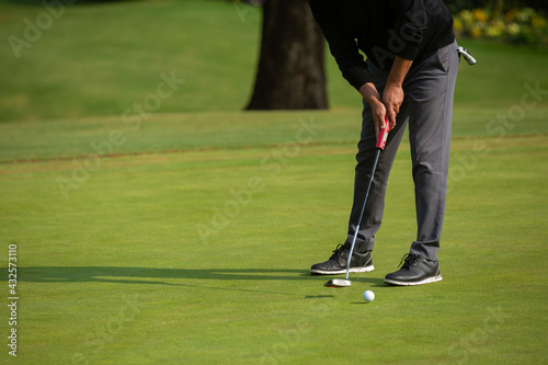 Man playing golf, putting green