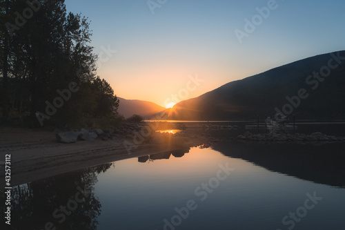 A beautiful  peaceful  serene  calm  idyllic summer sunset or sunrise on Kootenay Lake in Nelson  British Columbia  Canada