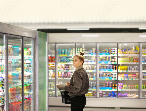 Woman choosing frozen food from a supermarket freezer