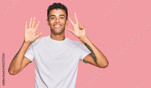 Young handsome african american man wearing casual white tshirt showing and pointing up with fingers number eight while smiling confident and happy.