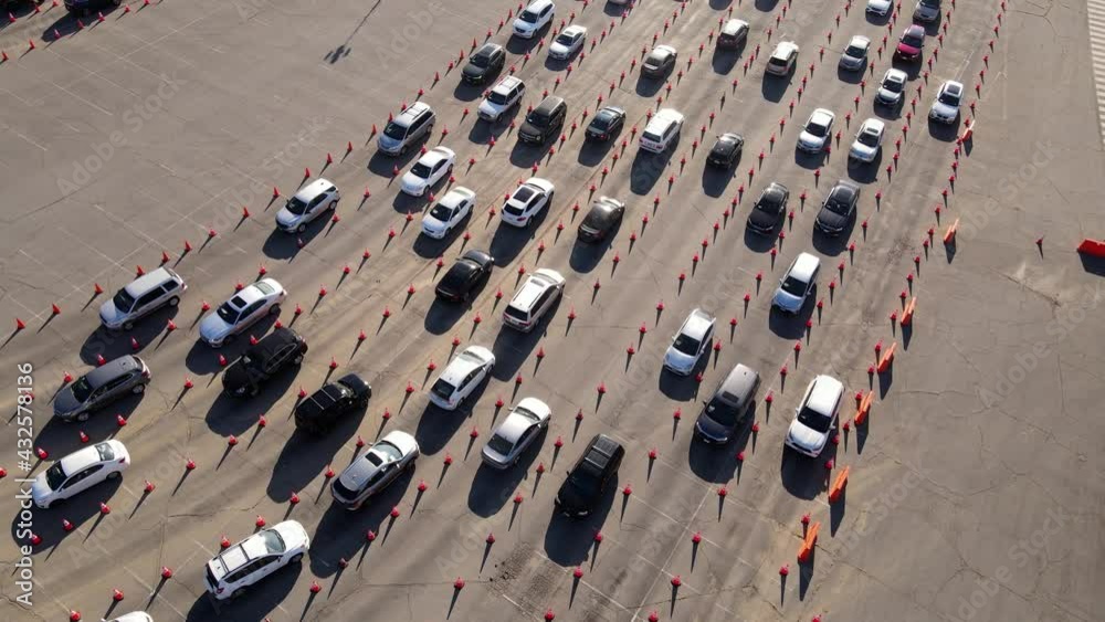 Aerial shot of 1000’s of people in cars waiting in line at a drive-through testing site to be tested for Coronavirus or to receive the vaccine.