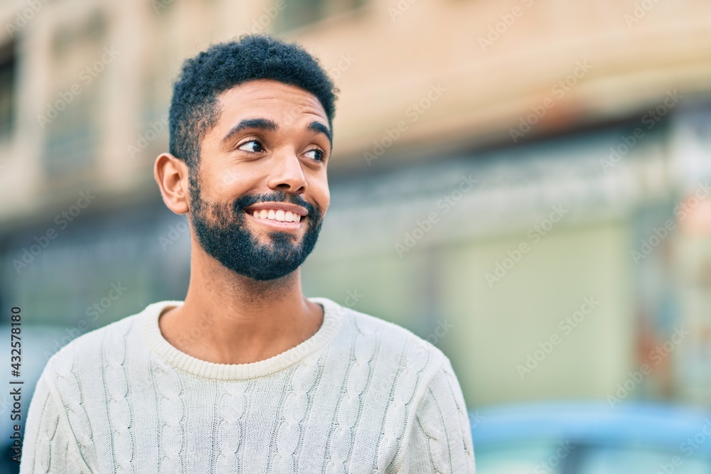 Young african american man smiling happy standing at the city. Young african american man smiling happy standing at the city.