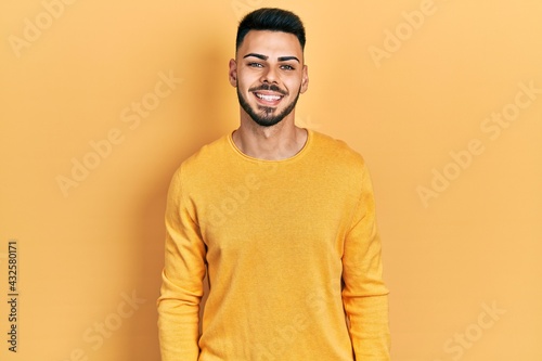 Young hispanic man with beard wearing casual winter sweater with a happy and cool smile on face. lucky person.