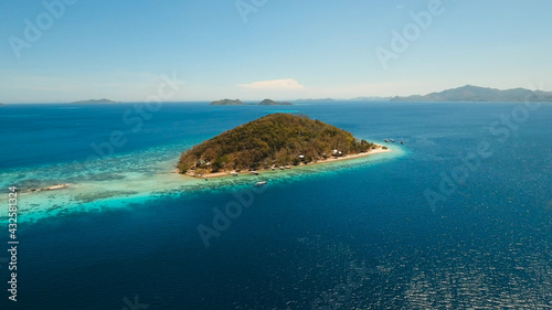 Aerial view of tropical beach on the island Banana, Philippines. Beautiful tropical island with sand beach, palm trees. Tropical landscape: beach with palm trees. Seascape: Ocean, sky, sea. Travel
