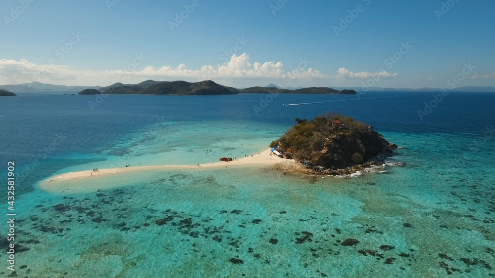 Aerial view of tropical beach on the Bulog Dos Island, Philippines. Beautiful tropical island with sand beach, palm trees. Tropical landscape: beach with palm trees. Seascape: Ocean, sky, sea. Travel