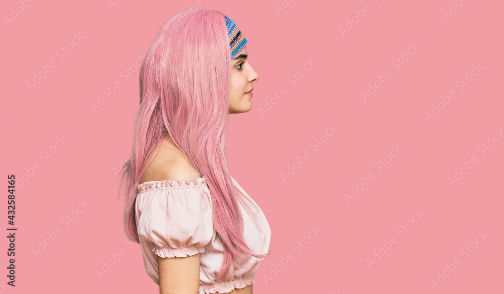 Young hispanic girl with pink hair looking to side, relax profile pose with natural face with confident smile. Young hispanic girl with pink hair looking to side, relax profile pose with natural face with confident smile.