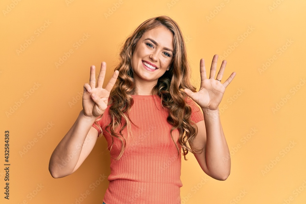 Young blonde girl wearing casual clothes showing and pointing up with fingers number eight while smiling confident and happy. Young blonde girl wearing casual clothes showing and pointing up with fingers number eight while smiling confident and happy.