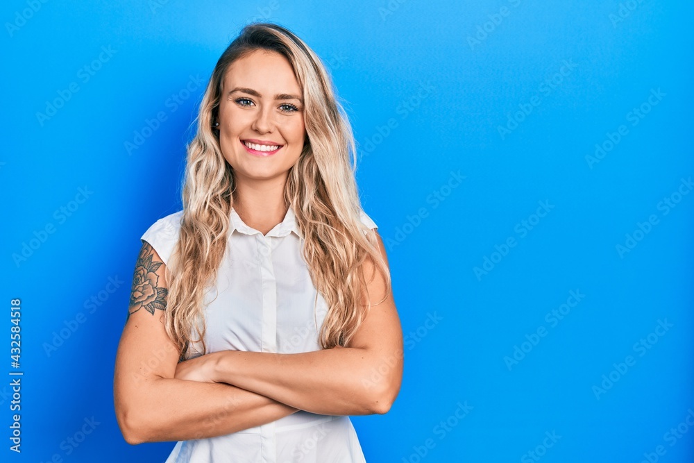 Beautiful young blonde woman wearing casual white shirt happy face smiling with crossed arms looking at the camera. positive person. Beautiful young blonde woman wearing casual white shirt happy face smiling with crossed arms looking at the camera. positive person.