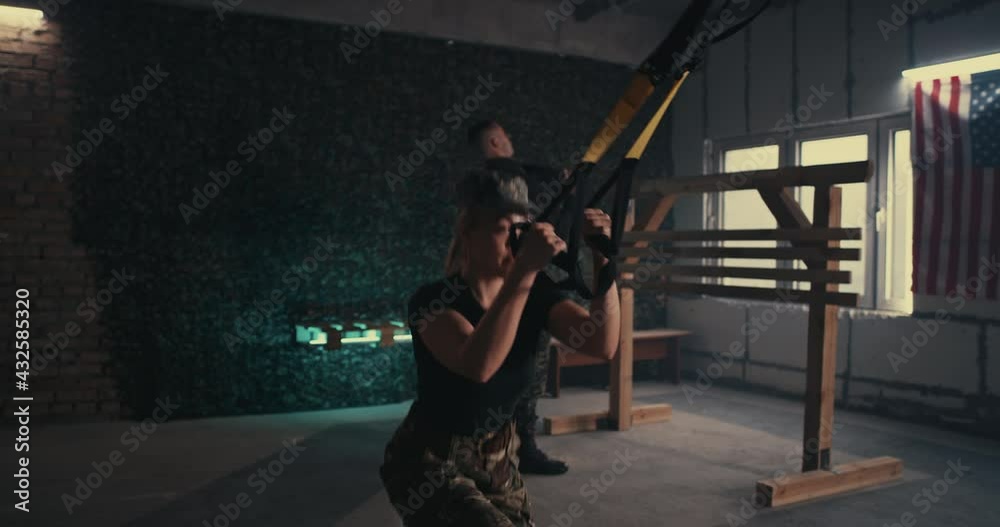 Female soldier doing TRX lunge near squadmate