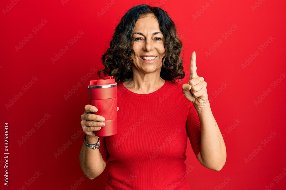 Middle age hispanic woman drinking a cup of coffee smiling with an idea or question pointing finger with happy face, number one Middle age hispanic woman drinking a cup of coffee smiling with an idea or question pointing finger with happy face, number one