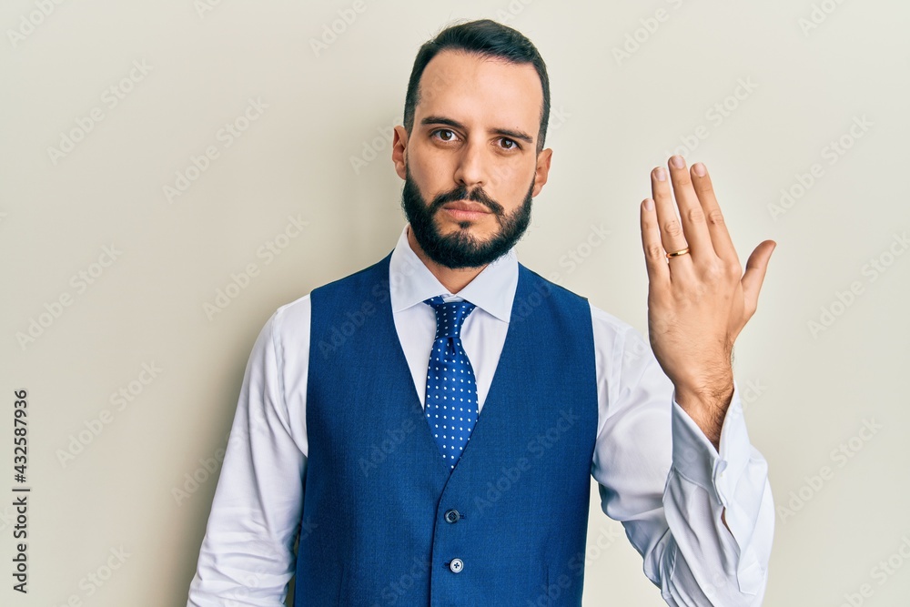 Young man with beard wearing engagement ring thinking attitude and sober expression looking self confident Young man with beard wearing engagement ring thinking attitude and sober expression looking self confident