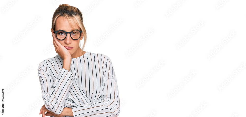 Beautiful blonde woman wearing business shirt and glasses thinking looking tired and bored with depression problems with crossed arms. Beautiful blonde woman wearing business shirt and glasses thinking looking tired and bored with depression problems with crossed arms.
