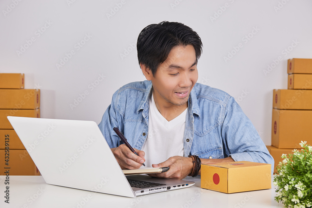 Online Merchant or Casual Businessman in Online Store Writing Customer Address in Notebook Online Merchant or Casual Businessman in Online Store Writing Customer Address in Notebook