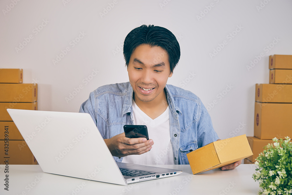 Online Merchant or Casual Businessman in Online Store Hold Parcel or Package and Using Smartphone to Check Order of Online Customer in Vintage Tone Online Merchant or Casual Businessman in Online Store Hold Parcel or Package and Using Smartphone to Check Order of Online Customer in Vintage Tone