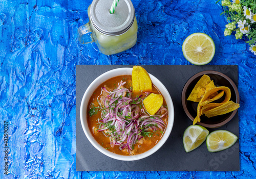 Top view of an encebollado, a typical food from Ecuador prepared with fish, onion, lemon and yucca on a blue background. In Ecuador it is usually eaten at breakfast photo