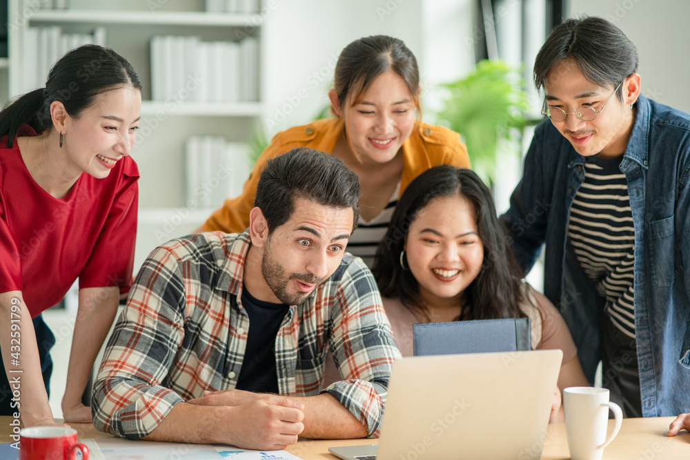 Business people in casual clothes looking something at laptop together with exciting face expression. Win a new project concept, happy from a good thing in workplace.