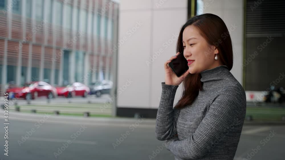 4k slow motion side view of Asian businesswoman making a phone call and walking on the city street 4k slow motion side view of Asian businesswoman making a phone call and walking on the city street