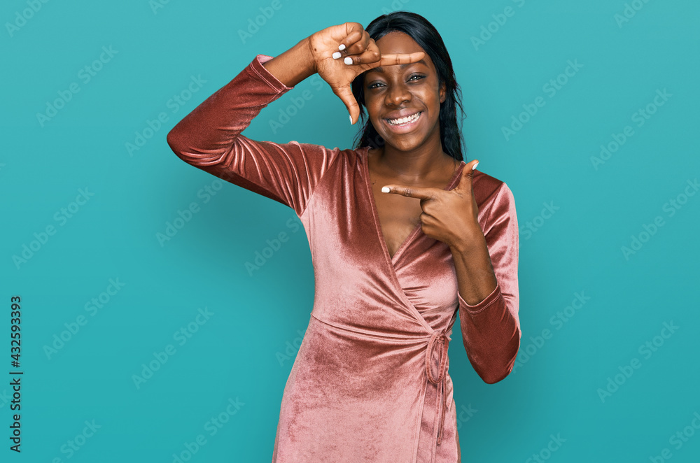 Fototapeta premium Young african american woman wearing sexy party dress smiling making frame with hands and fingers with happy face. creativity and photography concept.