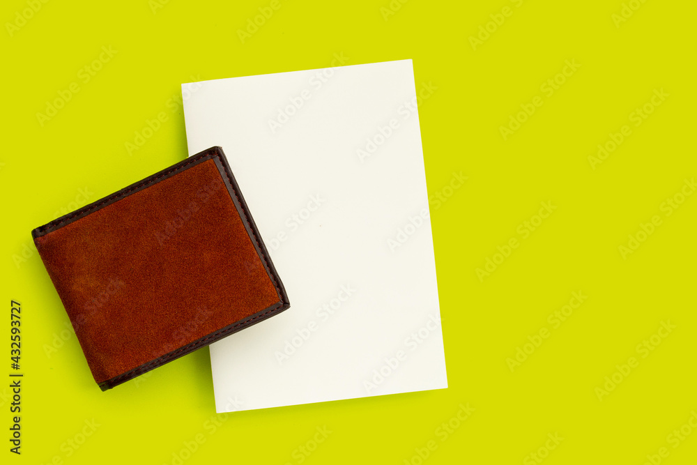 Brown wallet with white paper on green background. Brown wallet with white paper on green background.