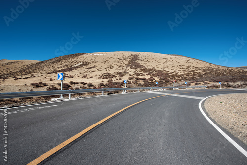 An open road under a snowy mountain