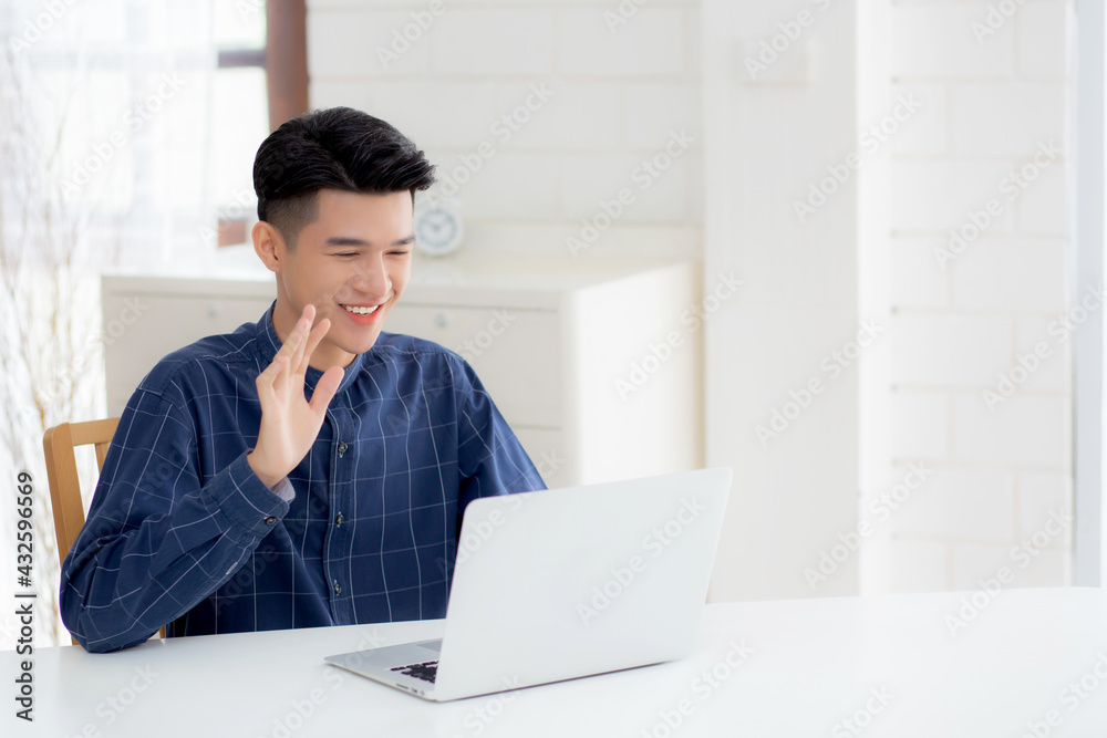 Young asian business man using laptop computer for video call online hello and communicate work from home, male conference with notebook and say hi, social distancing, communication concept. Young asian business man using laptop computer for video call online hello and communicate work from home, male conference with notebook and say hi, social distancing, communication concept.