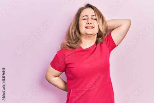 Middle age caucasian woman wearing casual clothes suffering of neck ache injury, touching neck with hand, muscular pain