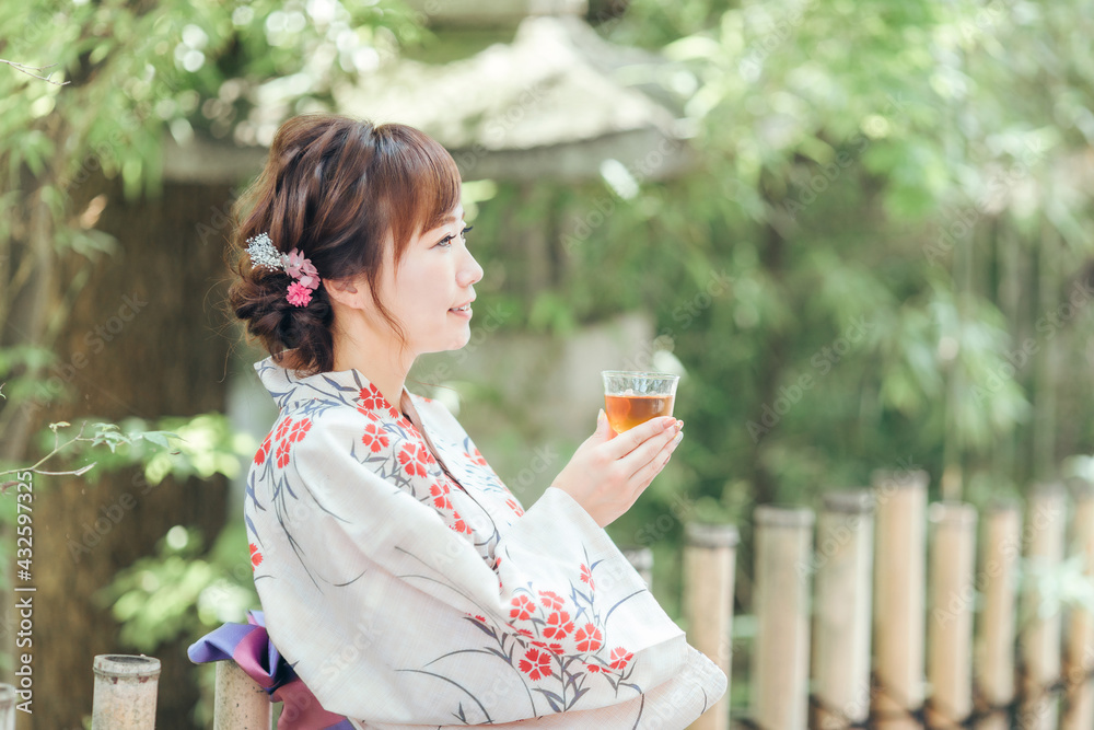Obraz premium 飲み物を飲む浴衣姿の女性 