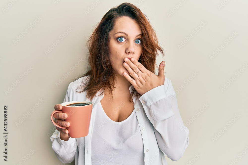 Young caucasian woman holding coffee covering mouth with hand, shocked and afraid for mistake. surprised expression Young caucasian woman holding coffee covering mouth with hand, shocked and afraid for mistake. surprised expression